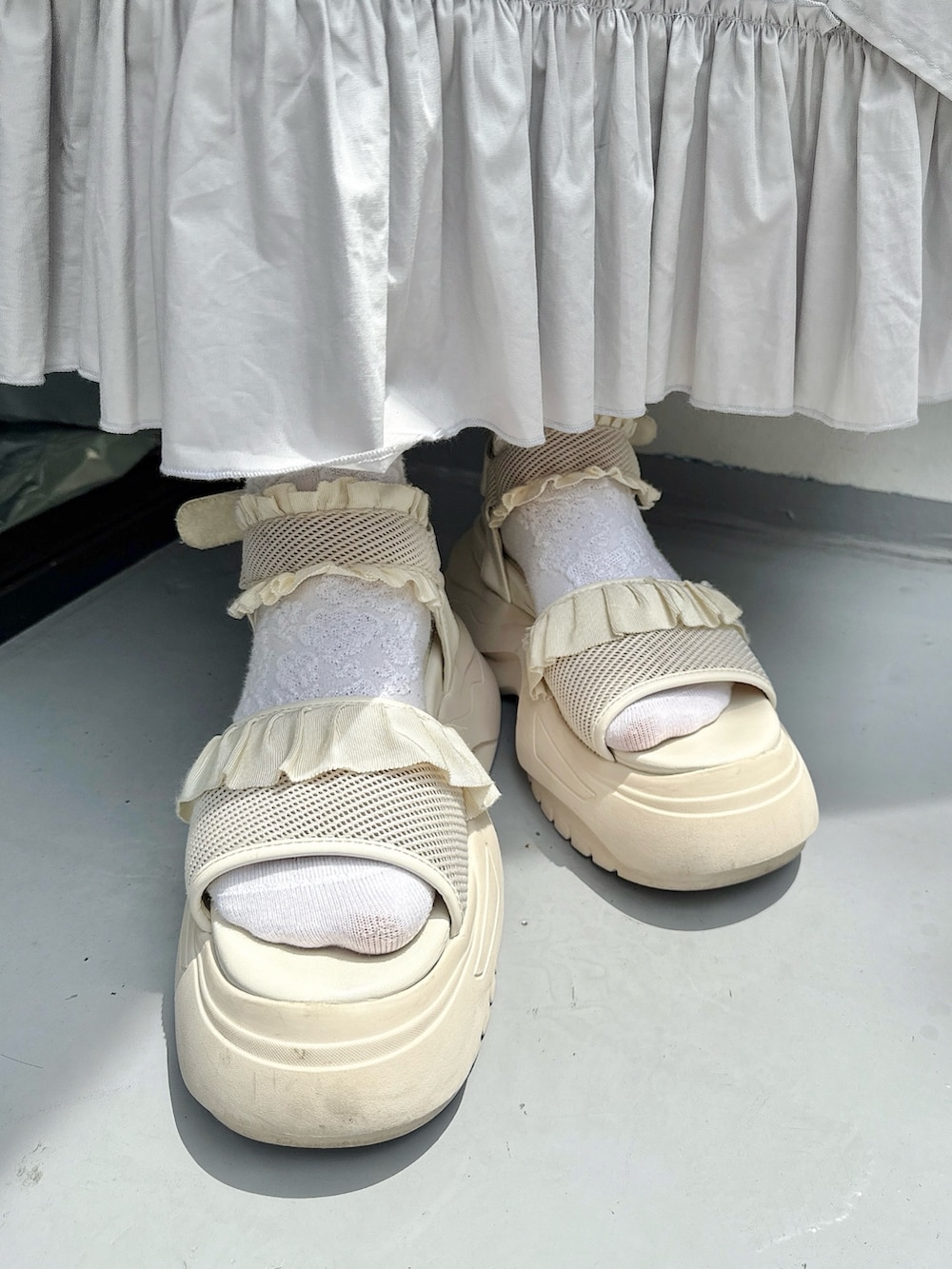 ホワイト系のカーディガン/ボレロ、グレー系のワンピース、ブルー系のTシャツ/カットソーを着用したレディースの春コーディネートの8枚目の写真