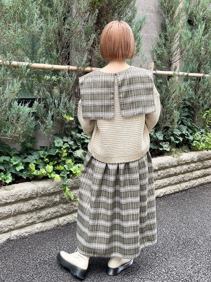 ホワイト系のブーツ、ゴールド系のカーディガン/ボレロ、グリーン系のワンピースを着用したレディースの秋コーディネートの3枚目の写真