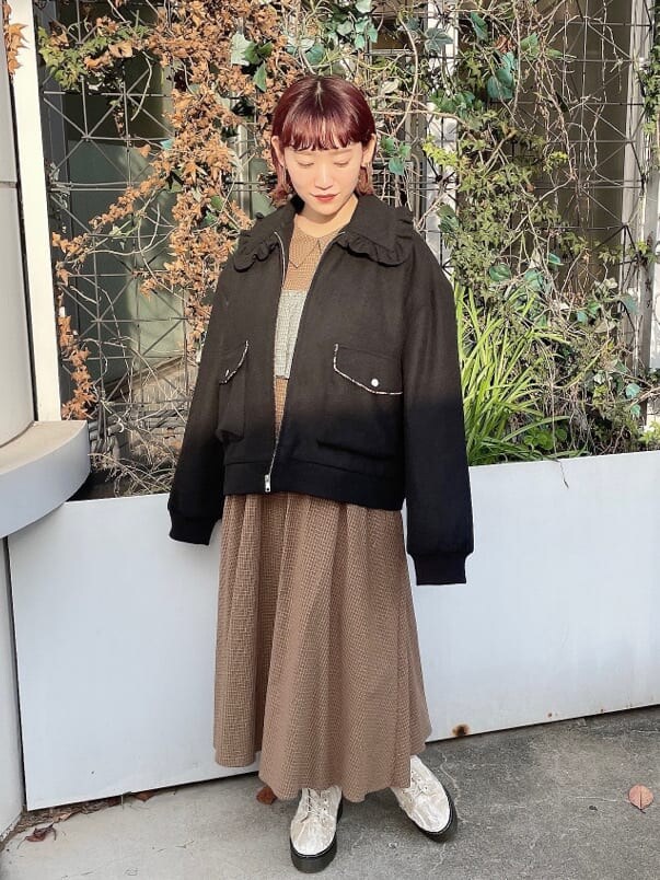 ホワイト系のブーツ、ブラック系のブルゾン、グリーン系のワンピースを着用したレディースの冬コーディネートの4枚目の写真