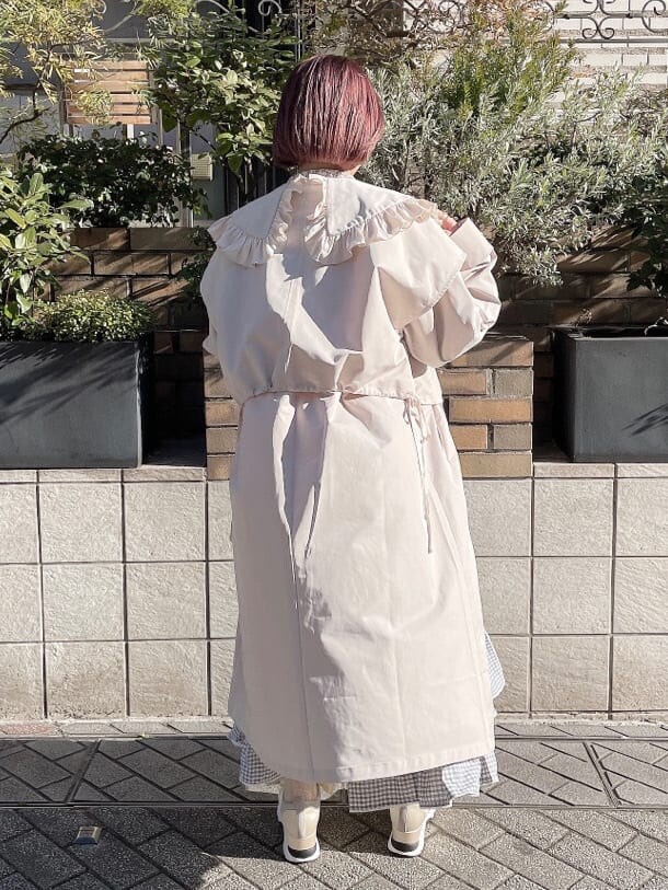 ホワイト系のトレンチコート、オレンジ系のシャツ/ブラウス、ブルー系のスカートを着用したレディースの冬コーディネートの2枚目の写真