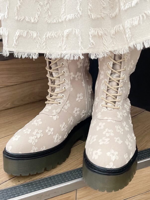 ベージュ系のドレス、グリーン系のハンドバッグ、ベージュ系のブーツを着用したレディースの夏コーディネートの8枚目の写真