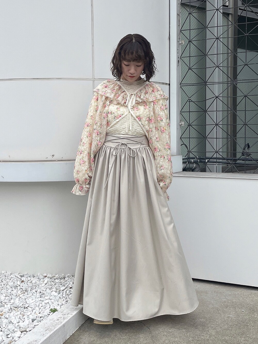 ホワイト系のカーディガン/ボレロ、ホワイト系のTシャツ/カットソー、ベージュ系のスカートを着用したレディースの冬コーディネートの3枚目の写真