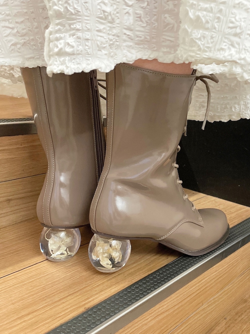 ホワイト系のワンピース、ベージュ系のブーツを着用したレディースの秋コーディネートの7枚目の写真