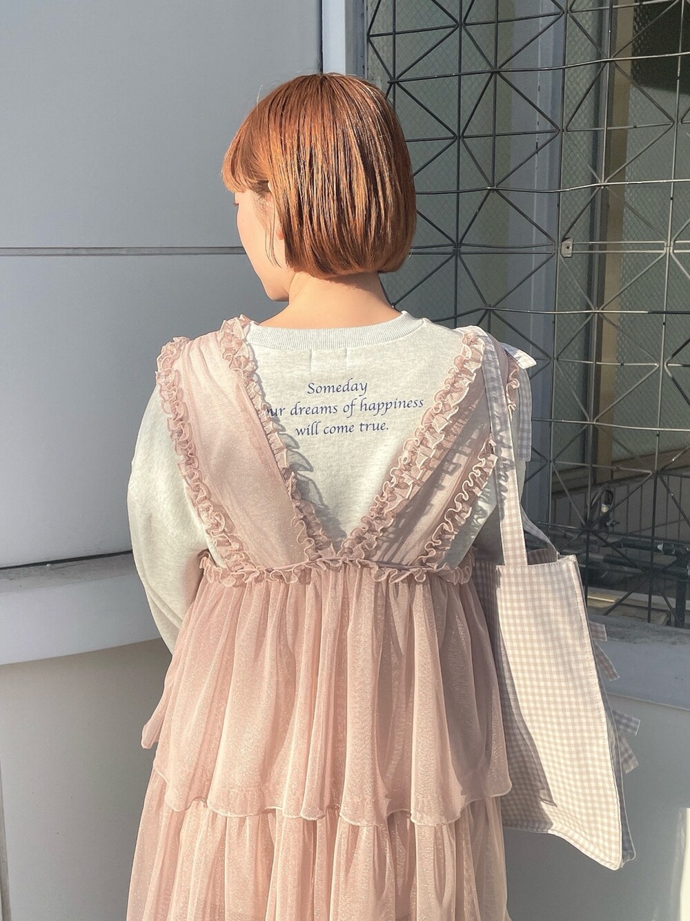 ベージュ系のトートバッグ、グレー系のスウェット、ピンク系のワンピースを着用したレディースの春コーディネートの6枚目の写真