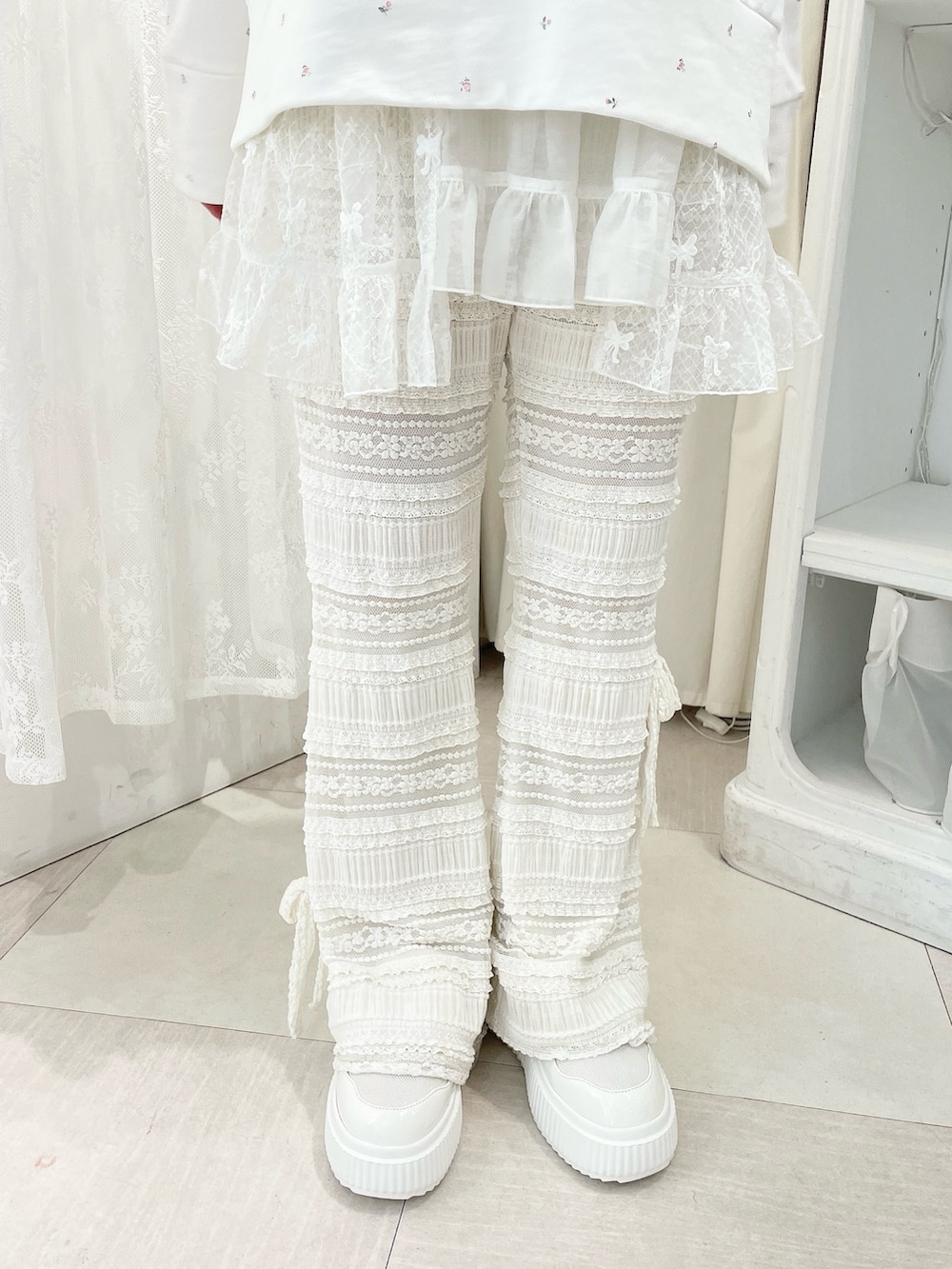 ホワイト系のスウェット、ホワイト系のスカート、ホワイト系のスニーカーを着用したレディースの冬コーディネートの7枚目の写真