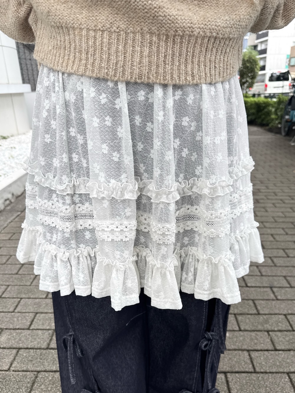 ブルー系のデニムパンツ、ホワイト系のスニーカー、ホワイト系のスカートを着用したレディースの夏コーディネートの5枚目の写真