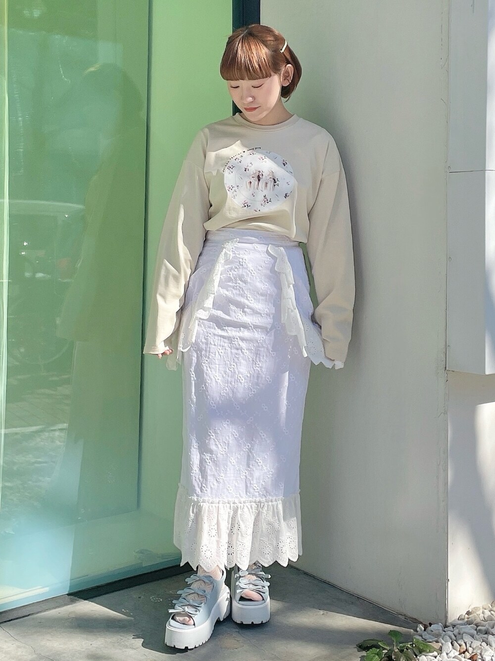 ホワイト系のスカート、ブルー系のサンダル、ベージュ系のTシャツ/カットソーを着用したレディースの冬コーディネートの2枚目の写真