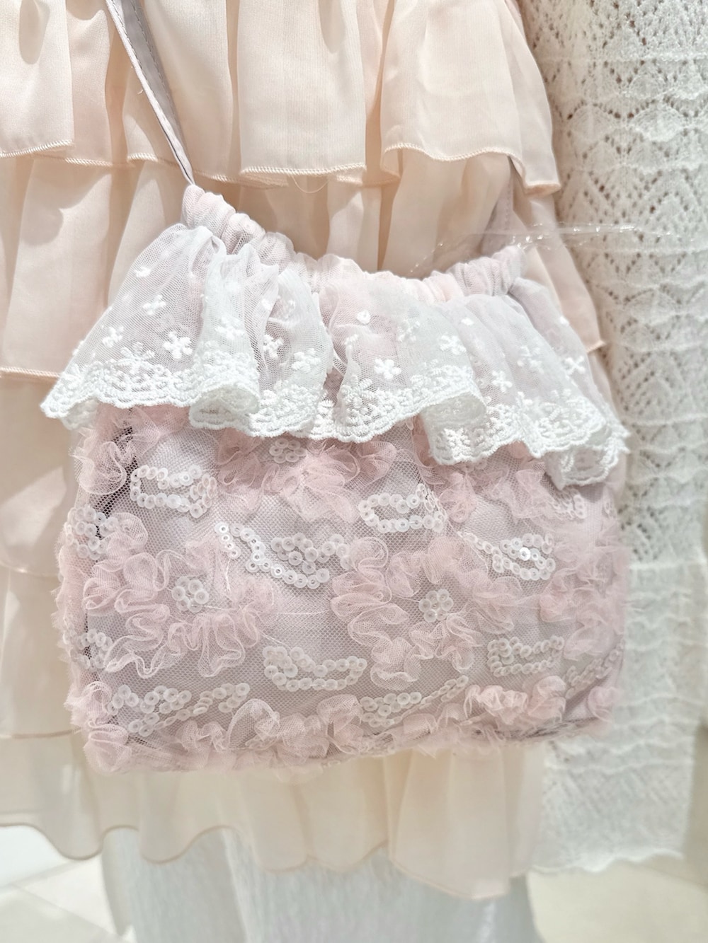 ピンク系のシャツ/ブラウス、ホワイト系のニット/セーター、ピンク系のハンドバッグを着用したレディースの夏コーディネートの7枚目の写真