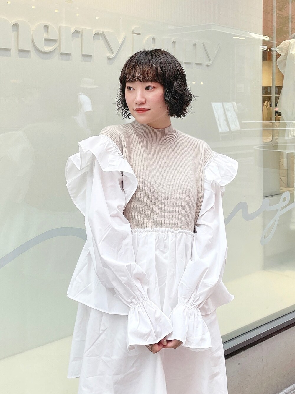 ベージュ系のワンピース、ホワイト系のスニーカー、ホワイト系のスウェットパンツを着用したレディースの秋コーディネートの4枚目の写真