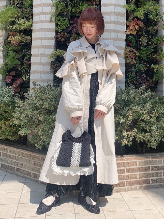 ホワイト系のトレンチコート、ブラック系のその他シューズを着用したレディースの春コーディネートの2枚目の写真