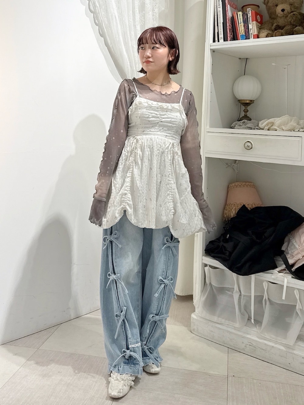 ホワイト系のワンピース、グレー系のTシャツ/カットソー、ブルー系のデニムパンツを着用したレディースの春コーディネートの2枚目の写真