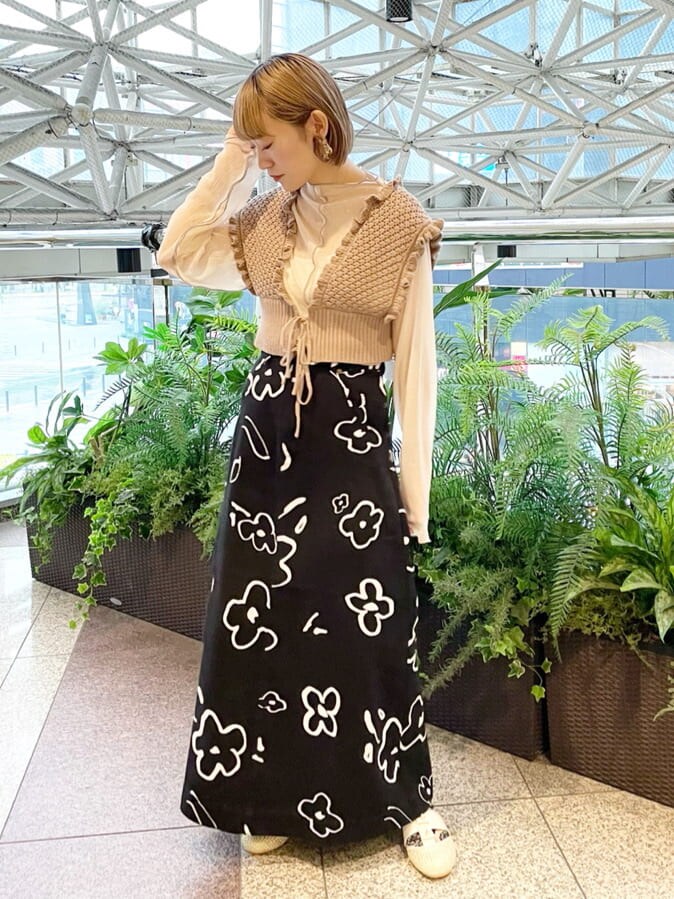 ベージュ系のニット/セーター、ホワイト系のチュニック、ブラック系のスカートを着用したレディースの夏コーディネートの2枚目の写真