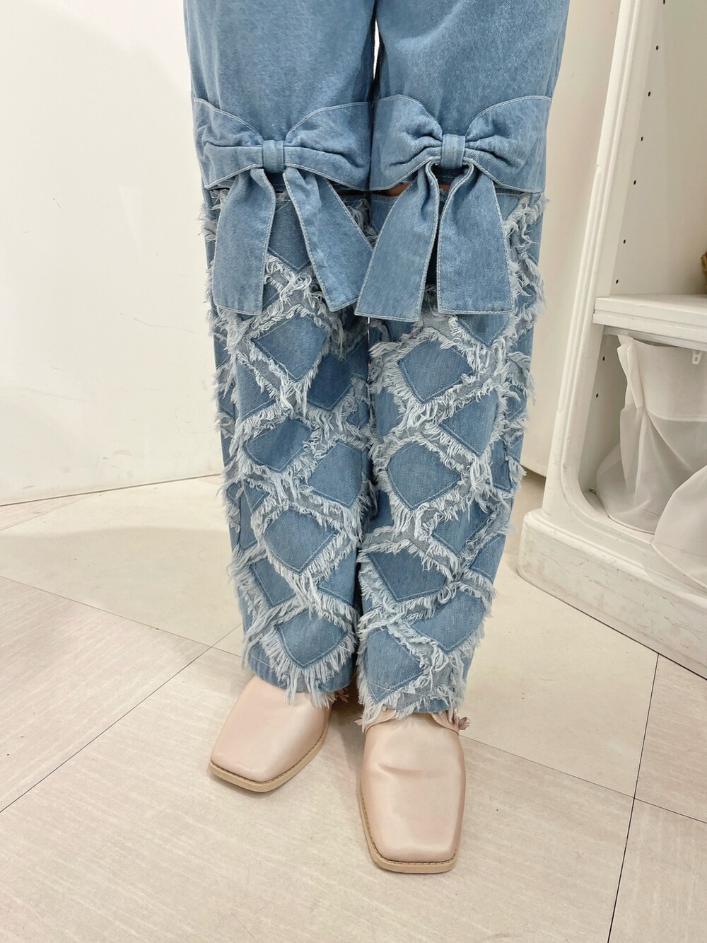 ホワイト系のTシャツ/カットソー、ピンク系のカーディガン/ボレロ、ブルー系のデニムパンツを着用したレディースの春コーディネートの5枚目の写真