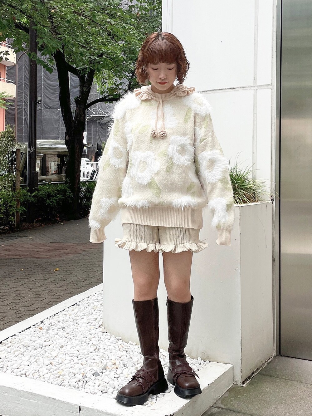 ホワイト系のニット/セーター、ホワイト系のスウェットパンツ、ブラウン系のブーツを着用したレディースの夏コーディネートの2枚目の写真