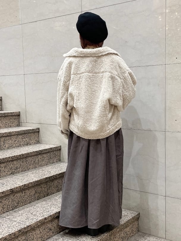 ブラック系のブーツ、ホワイト系のニット/セーター、ホワイト系のカバーオールを着用したレディースの冬コーディネートの2枚目の写真