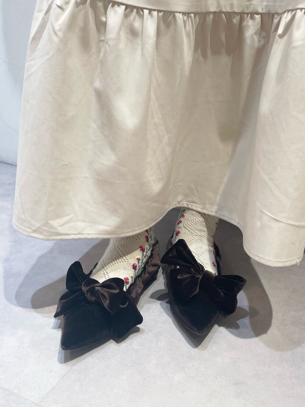 ピンク系のカーディガン/ボレロ、ホワイト系のワンピース、ブラウン系のパンプスを着用したレディースの冬コーディネートの5枚目の写真