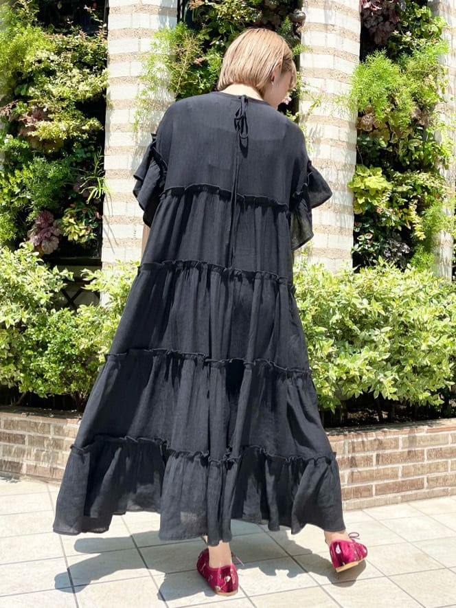 ブラック系のワンピース、レッド系のその他シューズ、パープル系のハンドバッグを着用したレディースの夏コーディネートの2枚目の写真