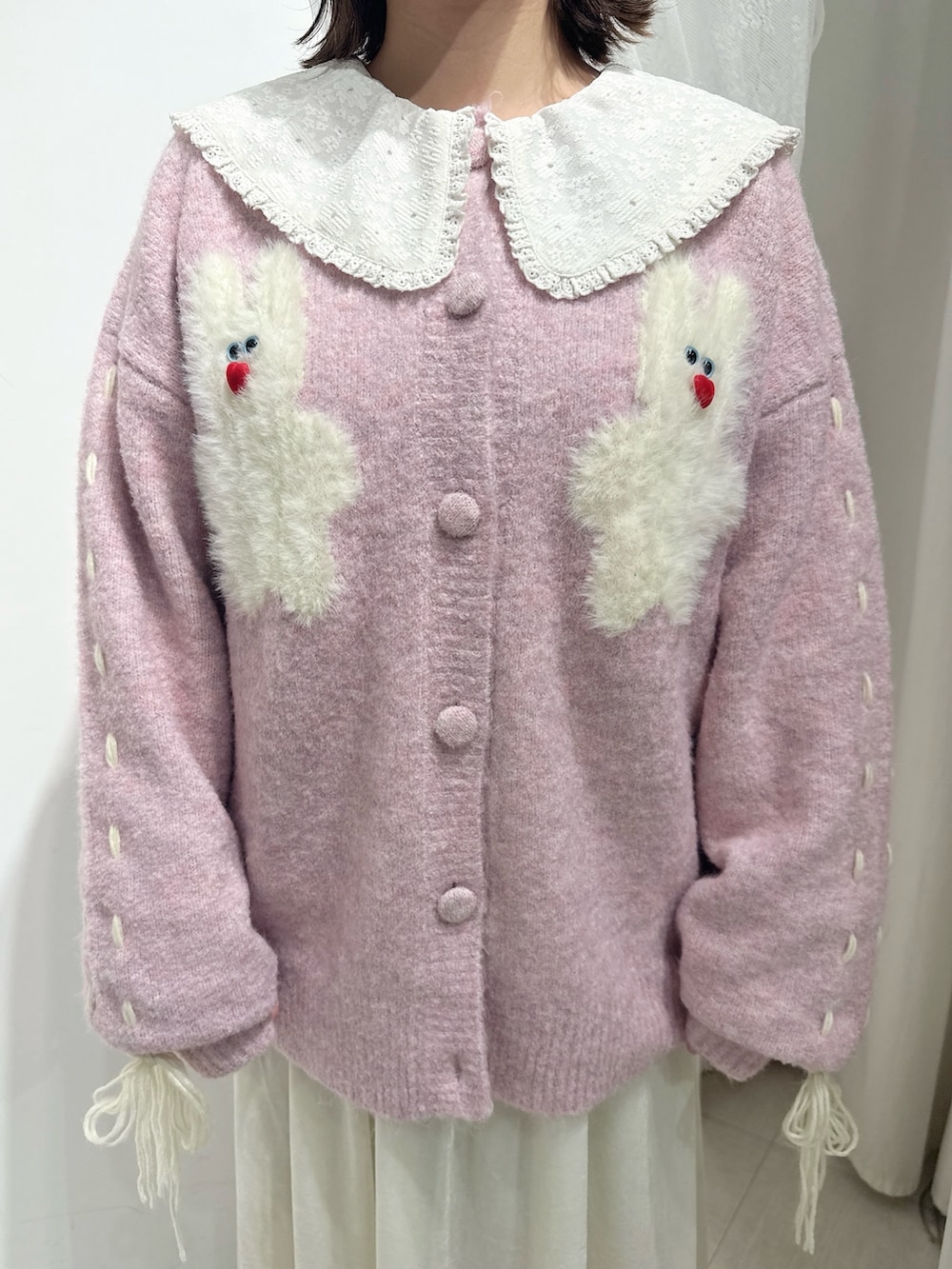 ピンク系のブーツ、ピンク系のカーディガン/ボレロ、ホワイト系のワンピースを着用したレディースの秋コーディネートの7枚目の写真