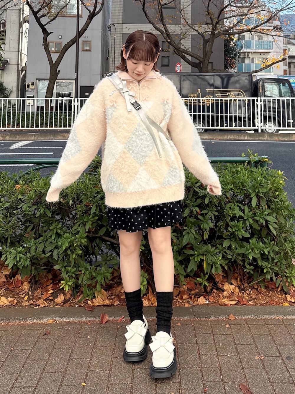 ピンク系のニット/セーター、グレー系のショルダーバッグ、ブラック系のスカートを着用したレディースの冬コーディネートの2枚目の写真