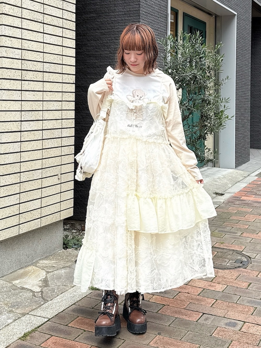 ベージュ系のTシャツ/カットソー、ホワイト系のワンピース、ホワイト系のスカートを着用したレディースの夏コーディネートの2枚目の写真