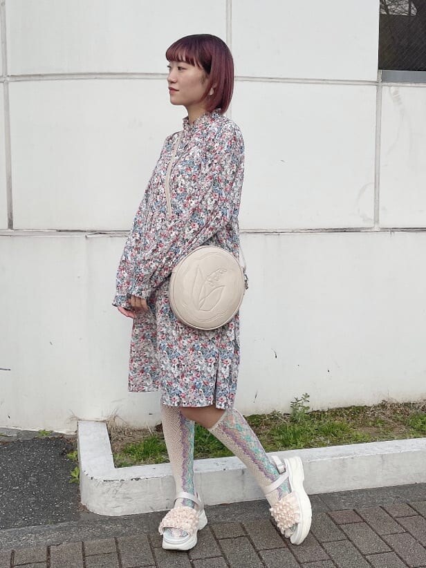 ピンク系のワンピース、ホワイト系のショルダーバッグ、ホワイト系のサンダルを着用したレディースの冬コーディネートの2枚目の写真