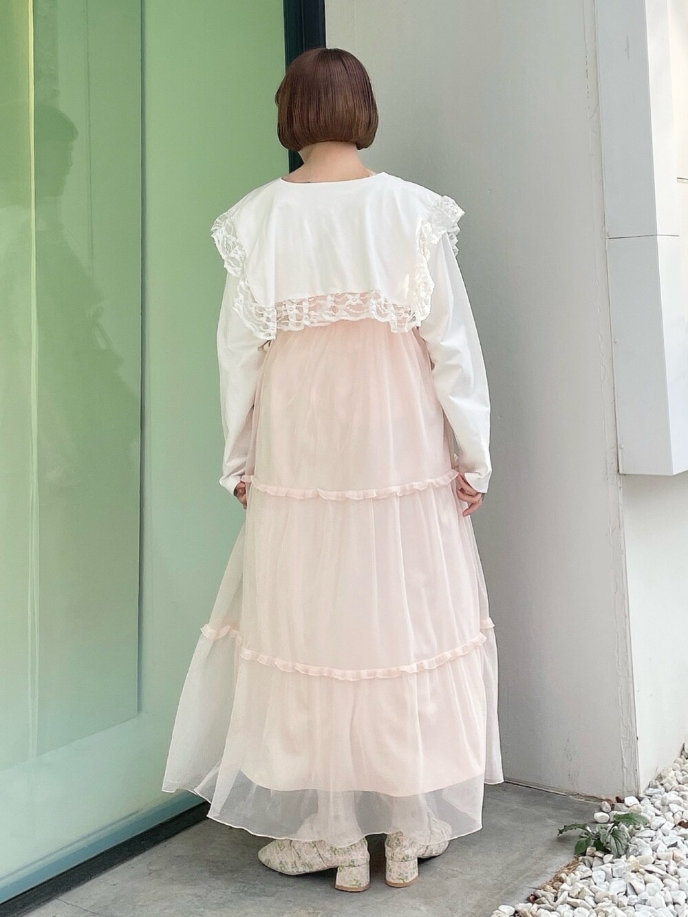 ホワイト系のTシャツ/カットソー、ホワイト系のショルダーバッグ、ピンク系のワンピースを着用したレディースの冬コーディネートの3枚目の写真