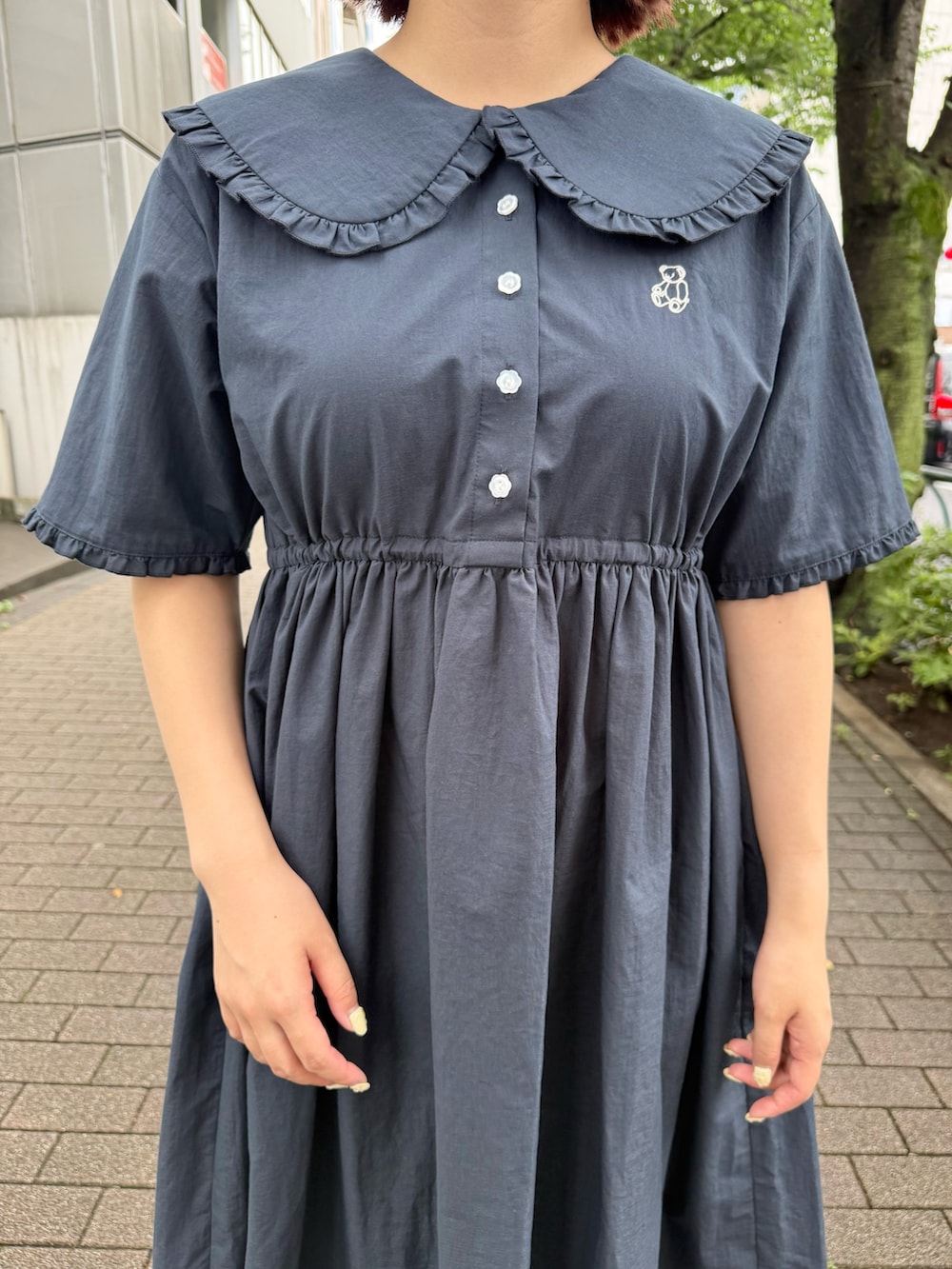 ブルー系のワンピース、レッド系のハンドバッグ、ブラック系のスニーカーを着用したレディースの夏コーディネートの4枚目の写真