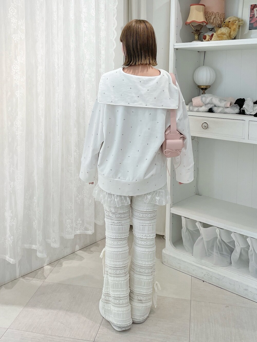 ホワイト系のスウェット、ホワイト系のスカート、ホワイト系のスニーカーを着用したレディースの冬コーディネートの3枚目の写真