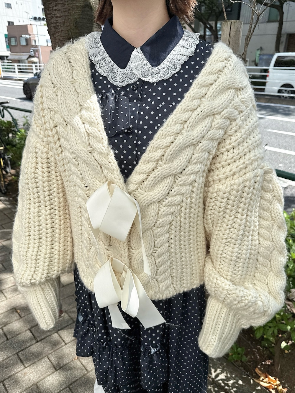 ホワイト系のカーディガン/ボレロ、ピンク系のハンドバッグ、ブラック系のローファーを着用したレディースの秋コーディネートの7枚目の写真