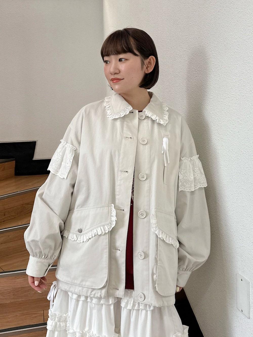 ホワイト系のミリタリージャケット、レッド系のスウェット、ホワイト系のスカートを着用したレディースの夏コーディネートの5枚目の写真