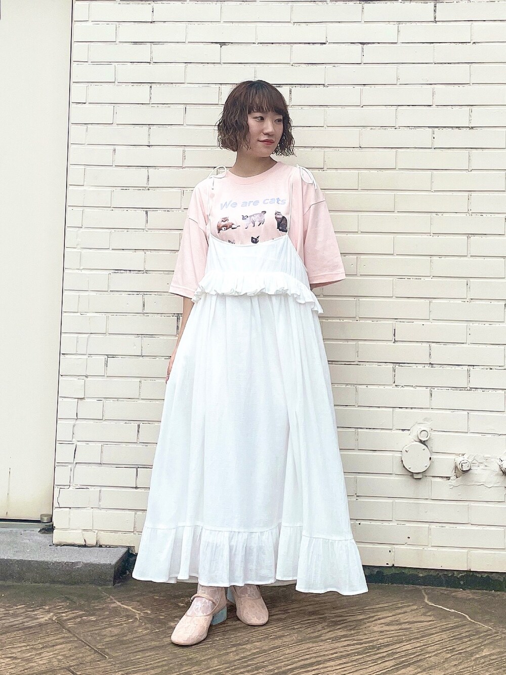 ホワイト系のスカート、ピンク系のTシャツ/カットソー、ピンク系のパンプスを着用したレディースの夏コーディネートの2枚目の写真
