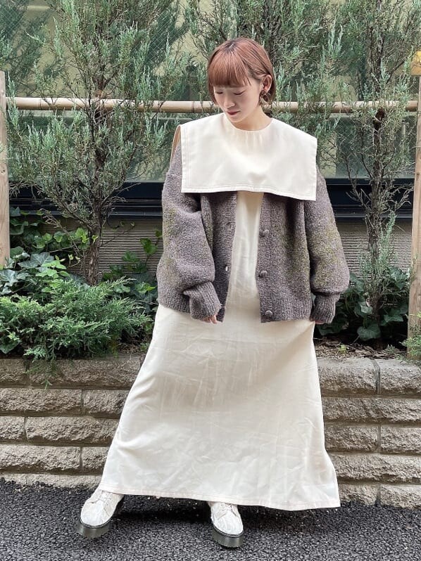 ホワイト系のワンピース、グレー系のカーディガン/ボレロ、ホワイト系のブーツを着用したレディースの秋コーディネートの3枚目の写真