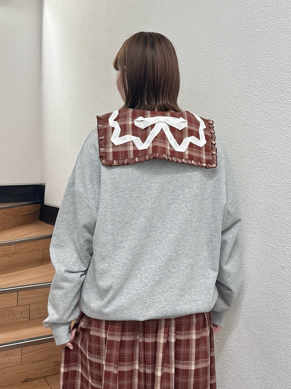 グレー系のスウェット、レッド系のワンピース、ブラウン系のハンドバッグを着用したレディースの秋コーディネートの6枚目の写真
