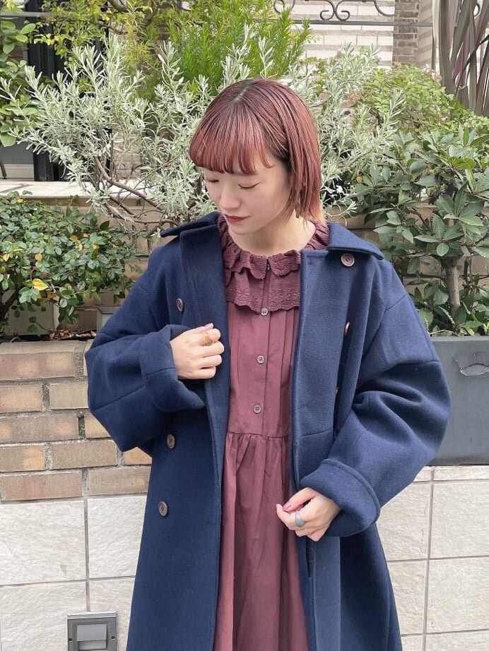 ブルー系のチェスターコート、レッド系のワンピース、その他のパンプスを着用したレディースの秋コーディネートの4枚目の写真