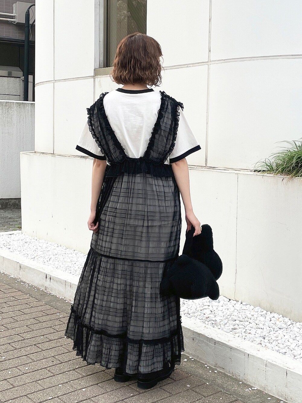 ホワイト系のTシャツ/カットソー、ブラック系のワンピース、ブラック系のハンドバッグを着用したレディースの春コーディネートの3枚目の写真