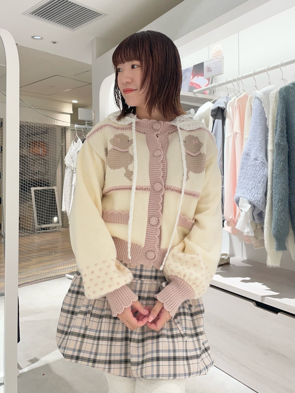 ホワイト系のスラックス、ホワイト系のTシャツ/カットソー、ピンク系のカーディガン/ボレロを着用したレディースの秋コーディネートの3枚目の写真