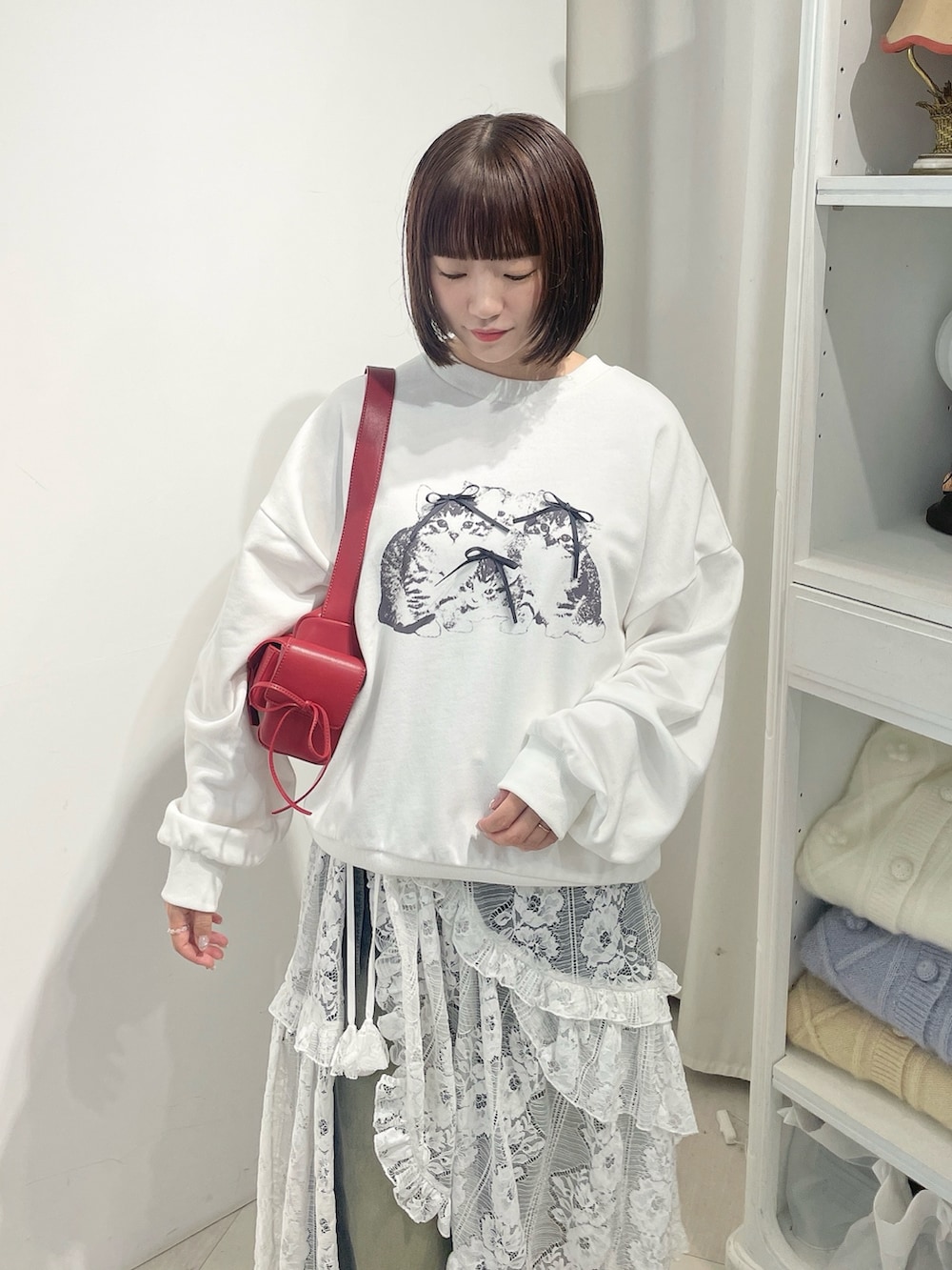 ホワイト系のスウェット、ホワイト系のスカート、ブルー系のデニムパンツを着用したレディースの秋コーディネートの5枚目の写真