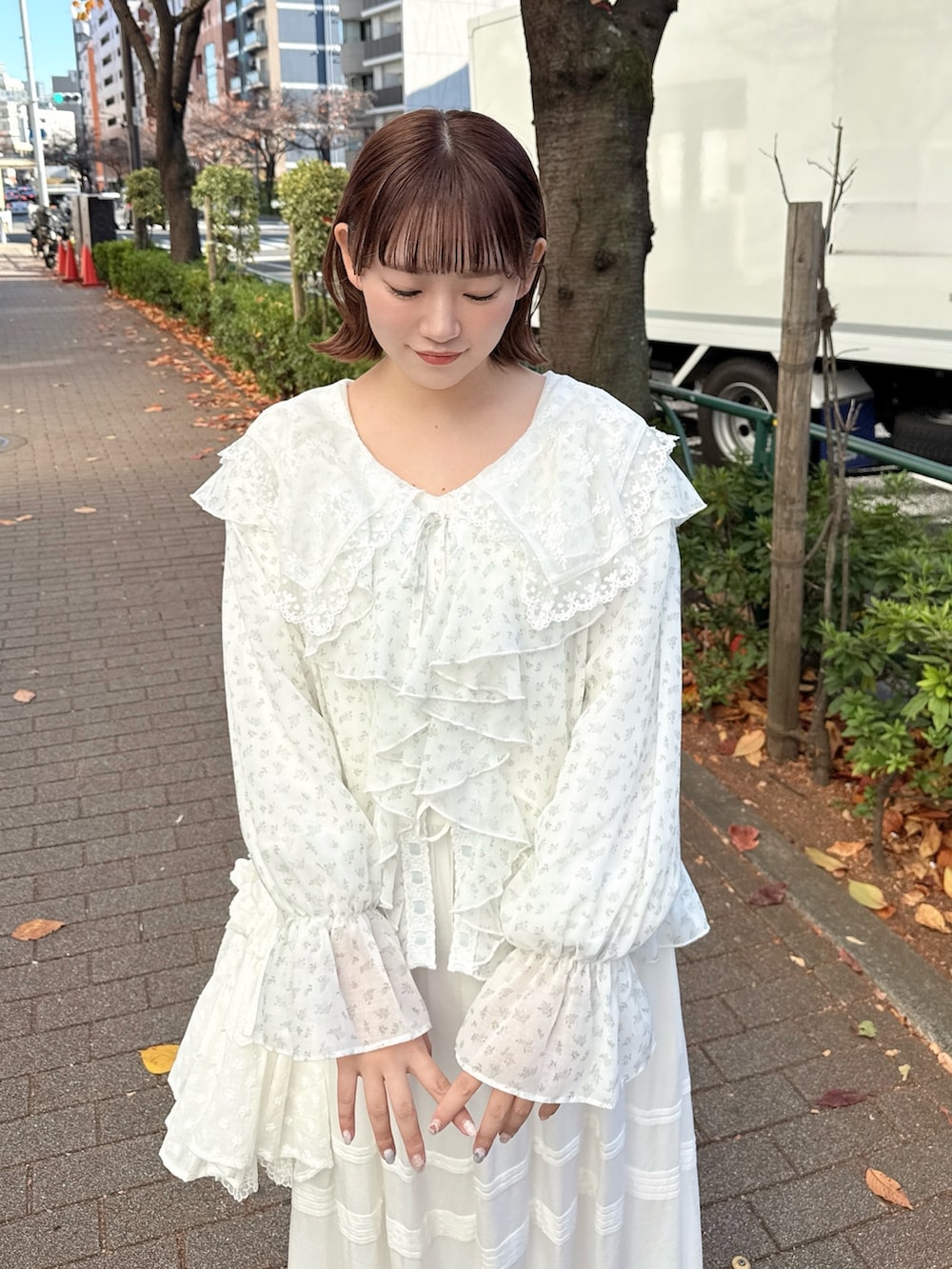 ホワイト系のワンピース、ブルー系のカーディガン/ボレロ、ホワイト系のショルダーバッグを着用したレディースの冬コーディネートの4枚目の写真