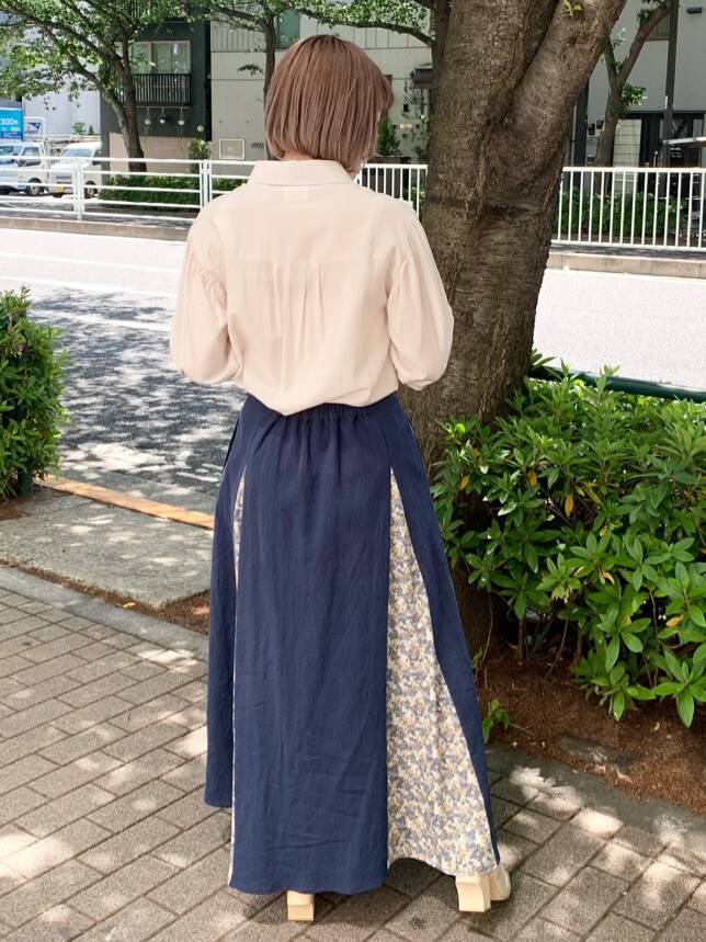 ホワイト系のパンプス、ベージュ系のシャツ/ブラウス、ブルー系のスカートを着用したレディースの春コーディネートの3枚目の写真