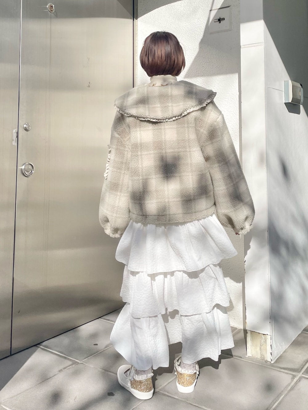 ホワイト系のスカート、ベージュ系のブルゾン、ホワイト系のニット/セーターを着用したレディースの冬コーディネートの3枚目の写真