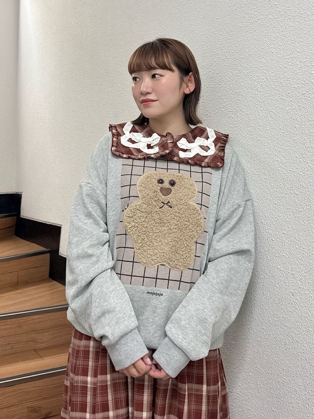 グレー系のスウェット、レッド系のワンピース、ブラウン系のハンドバッグを着用したレディースの秋コーディネートの4枚目の写真