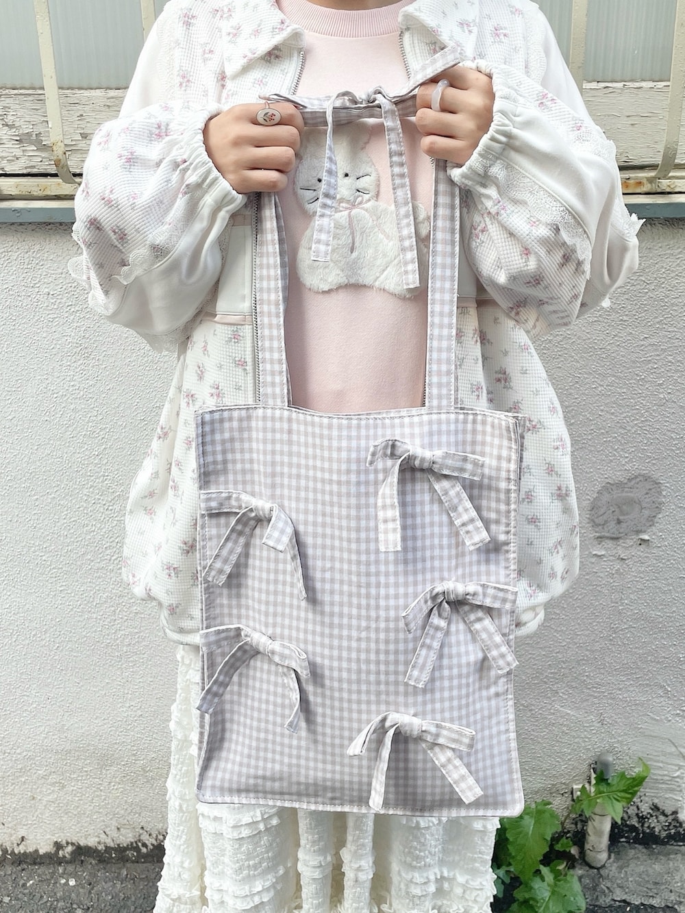 ピンク系のジャージ、ベージュ系のトートバッグ、ピンク系のスウェットを着用したレディースの冬コーディネートの9枚目の写真