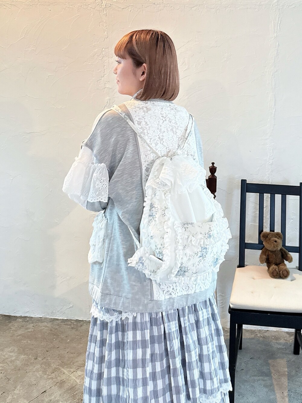 ブルー系のバックパック/リュック、グレー系のワンピース、ホワイト系のサンダルを着用したレディースの春コーディネートの7枚目の写真