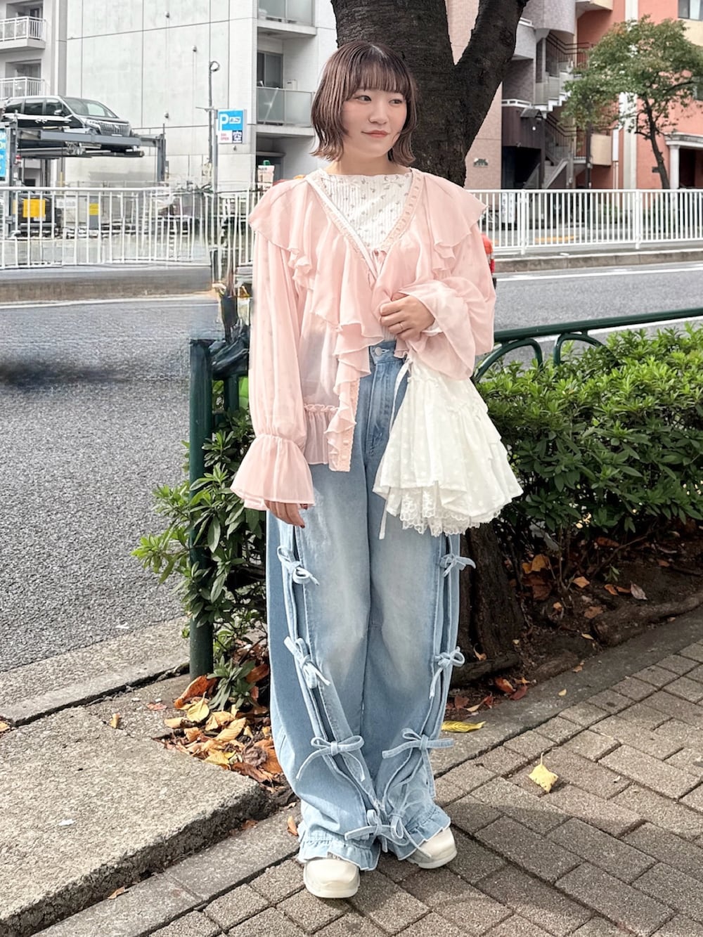 ピンク系のカーディガン/ボレロ、ピンク系のTシャツ/カットソー、ホワイト系のショルダーバッグを着用したレディースの秋コーディネートの2枚目の写真