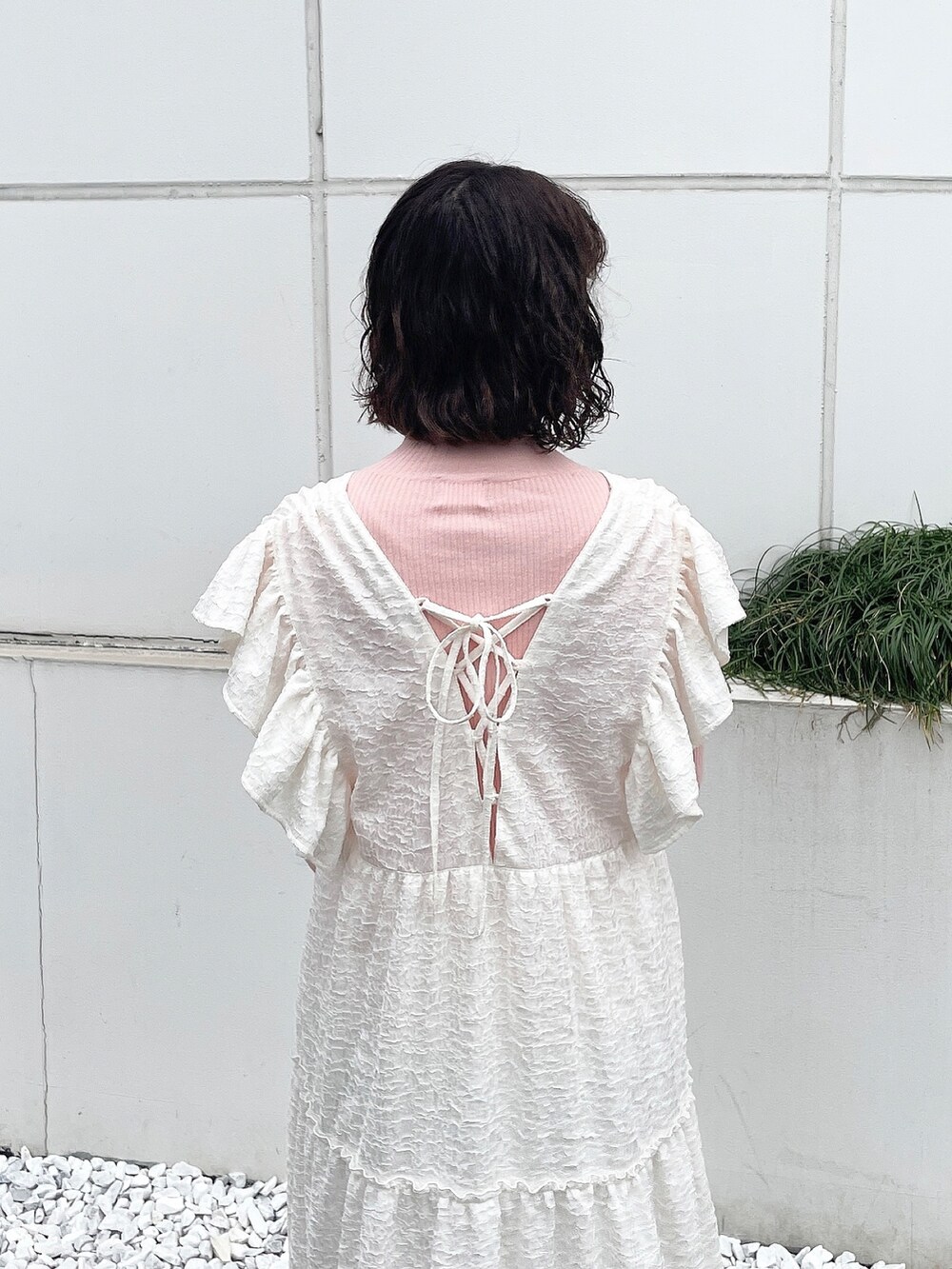 ピンク系のニット/セーター、ホワイト系のワンピース、ベージュ系のブーツを着用したレディースの冬コーディネートの5枚目の写真