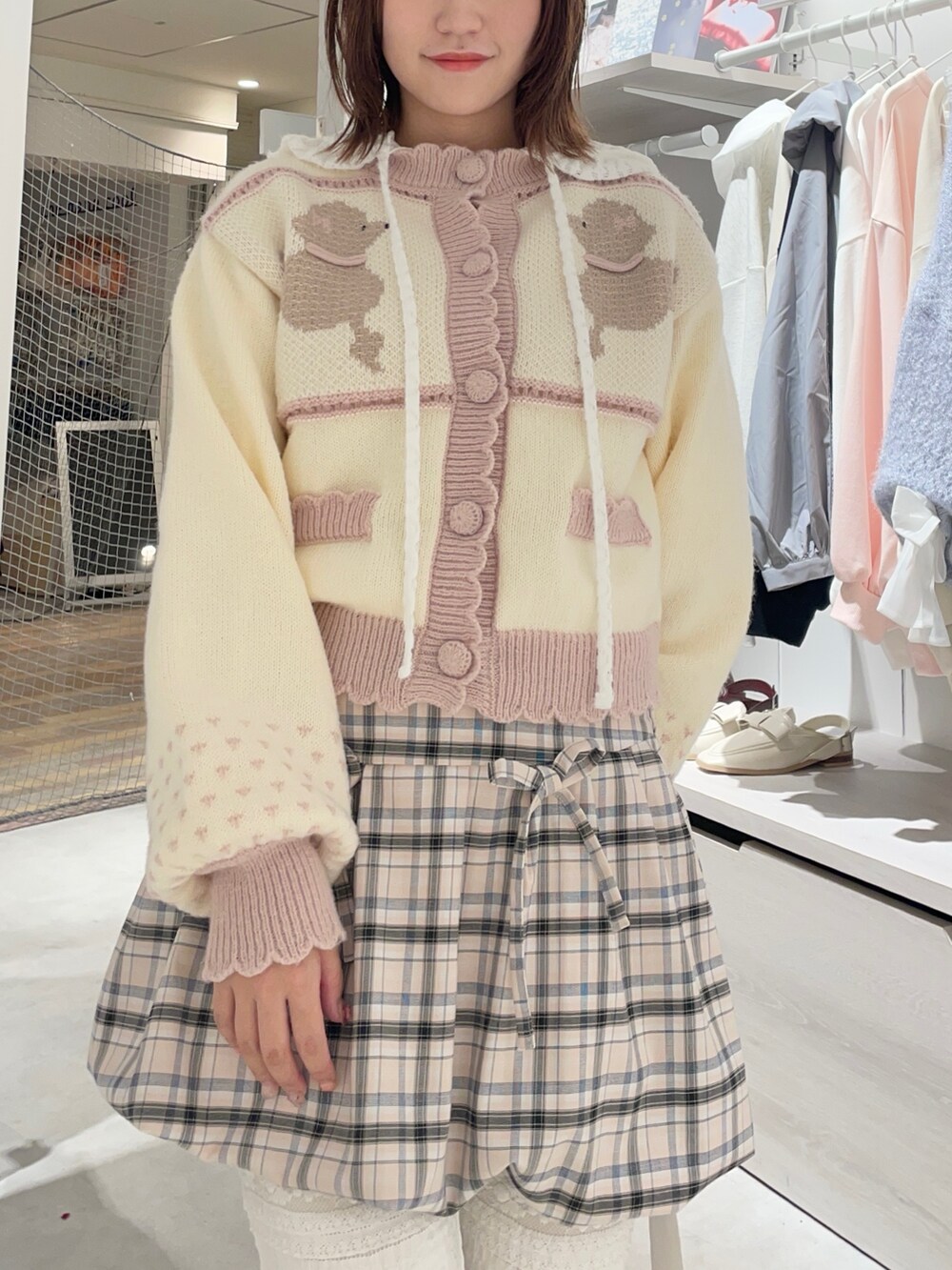 ホワイト系のスラックス、ホワイト系のTシャツ/カットソー、ピンク系のカーディガン/ボレロを着用したレディースの秋コーディネートの4枚目の写真