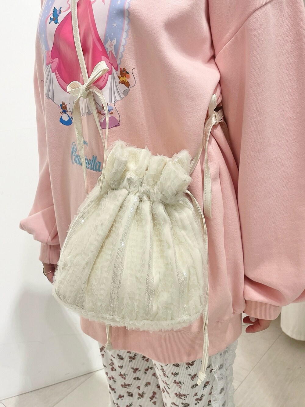 ホワイト系のバレエシューズ、レッド系のスウェットパンツ、ホワイト系のショルダーバッグを着用したレディースの冬コーディネートの7枚目の写真