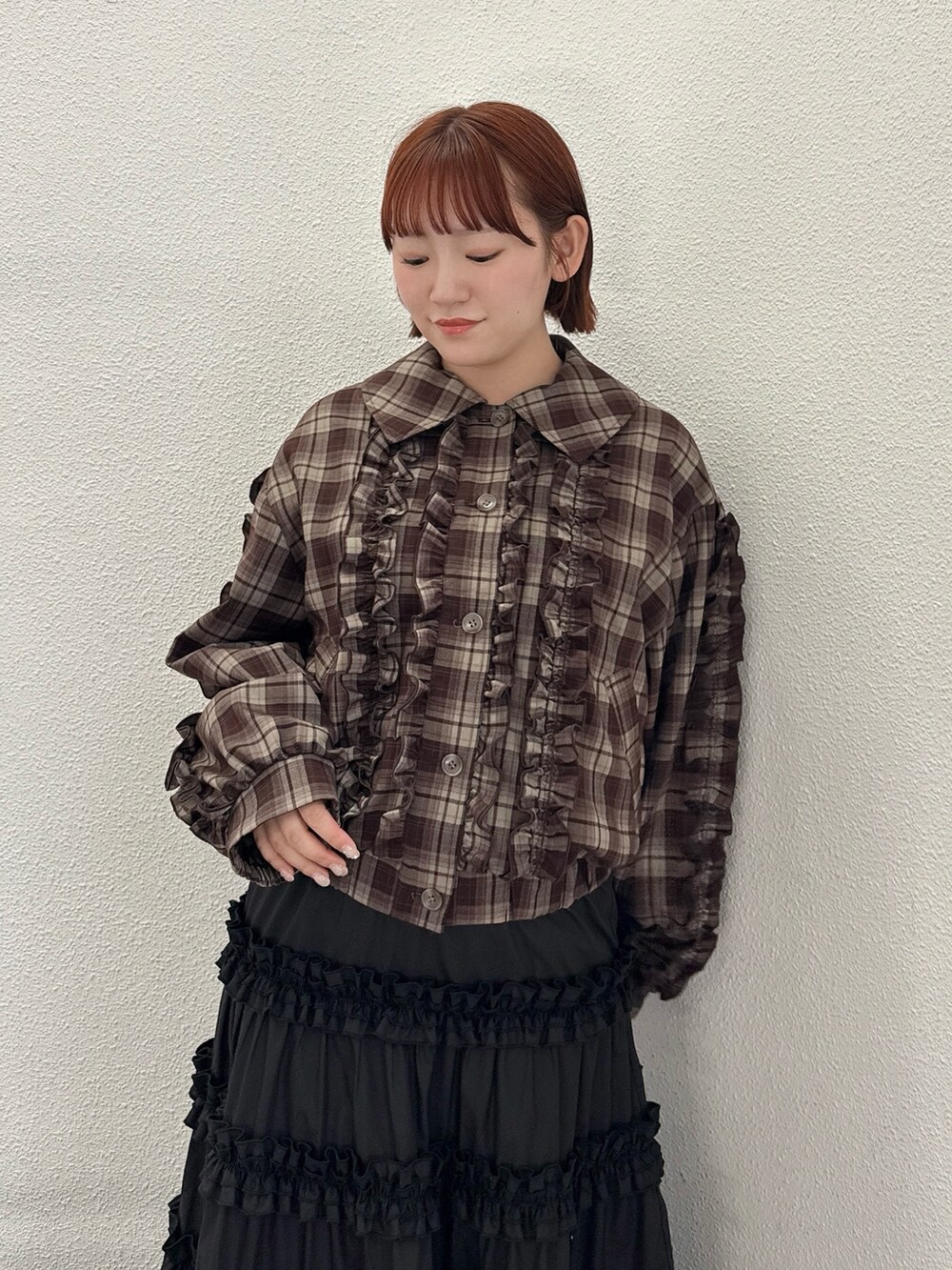 ブラウン系のブルゾン、ブラック系のスカート、ブラウン系のハンドバッグを着用したレディースの夏コーディネートの5枚目の写真