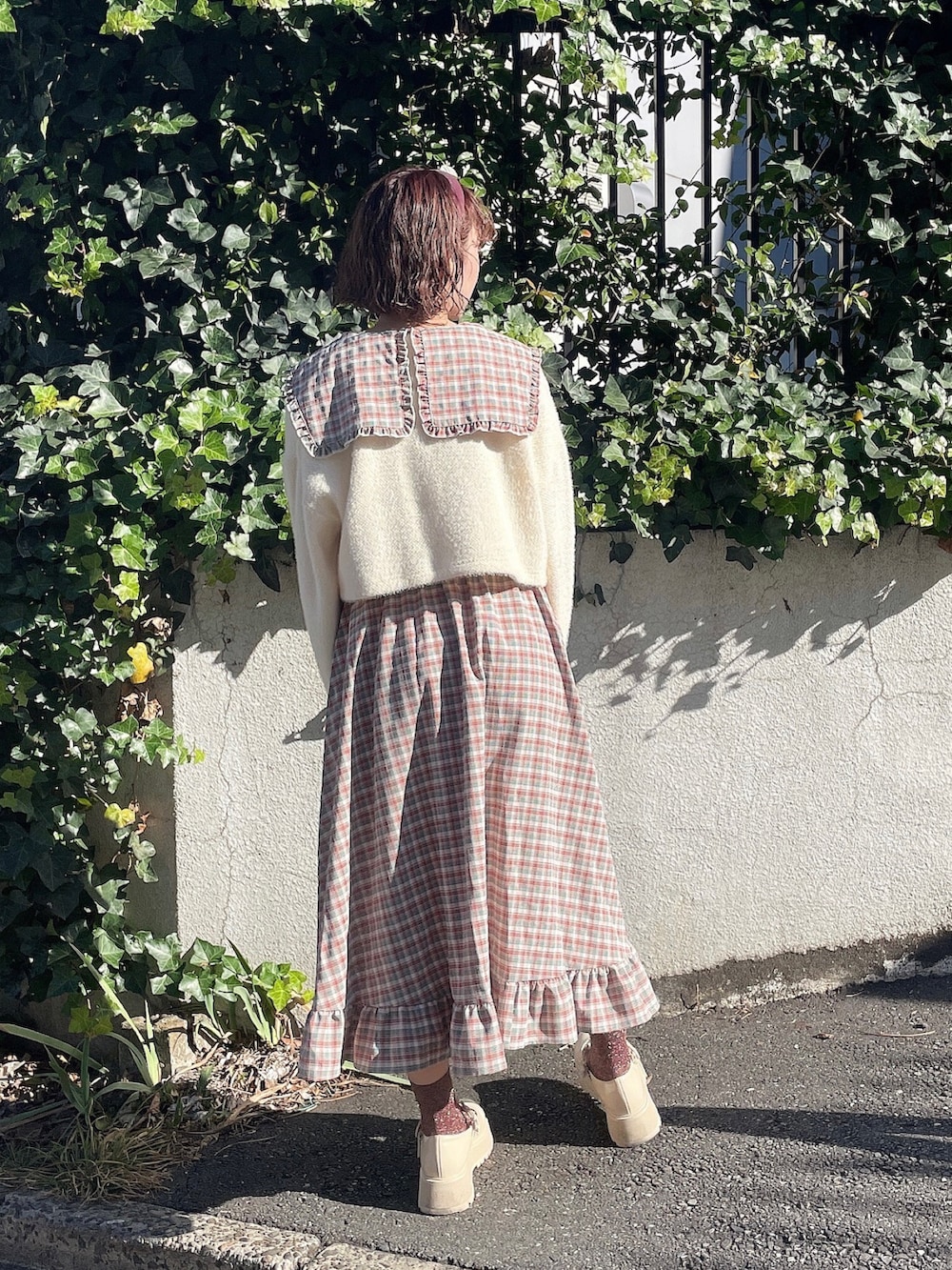 ホワイト系のカーディガン/ボレロ、ピンク系のワンピース、ホワイト系のローファーを着用したレディースの冬コーディネートの3枚目の写真