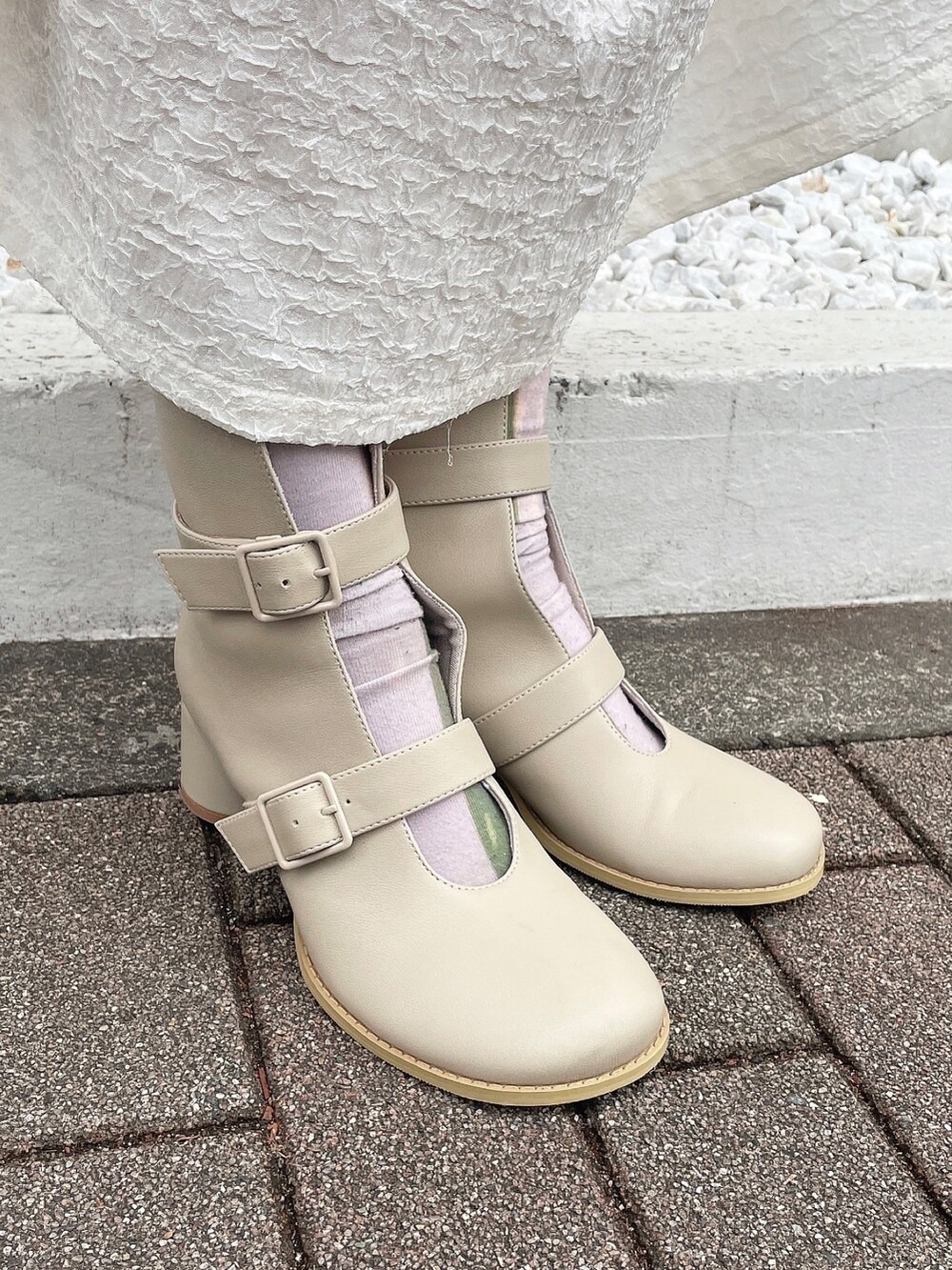 ピンク系のニット/セーター、ホワイト系のワンピース、ベージュ系のブーツを着用したレディースの冬コーディネートの6枚目の写真